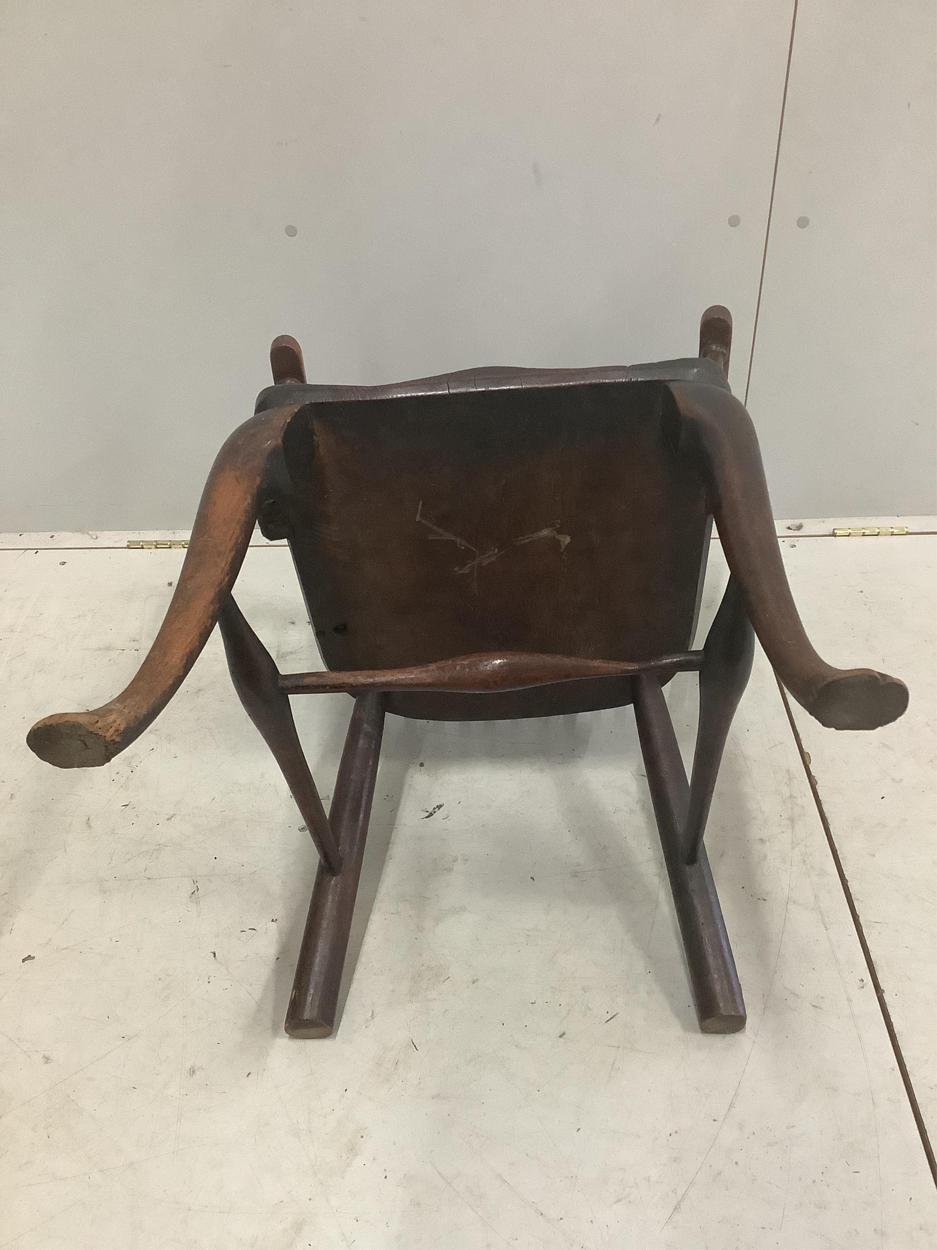 An early 18th century ash and elm primitive Windsor elbow chair on cabriole front legs, width 52cm, depth 43cm, height 89cm. Condition - fair